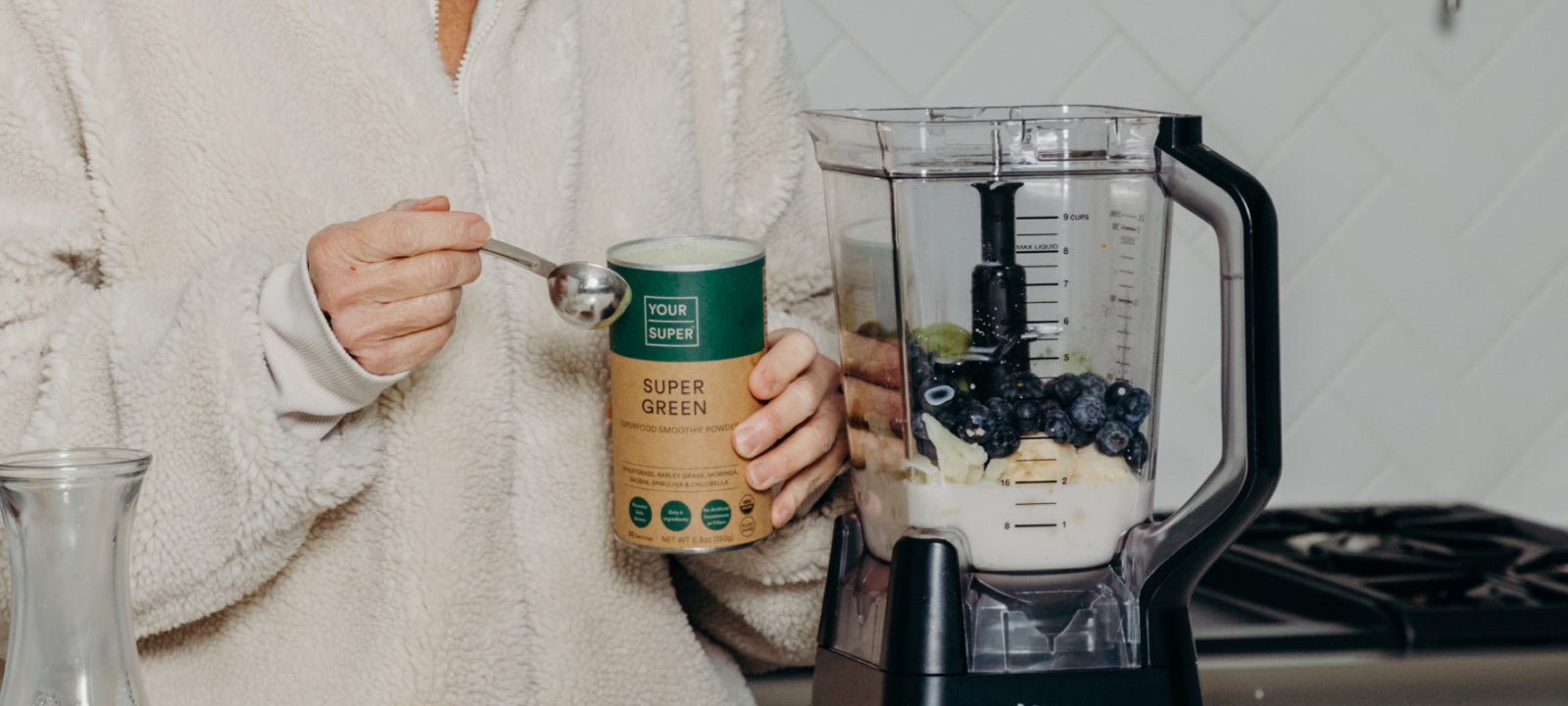 Frau bereitet einen Super Green Smoothie zu